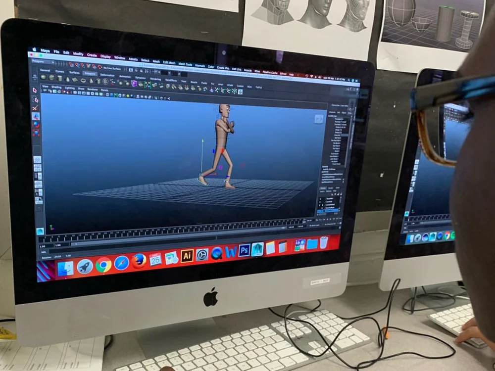A student working on a 3D character animation in a computer lab